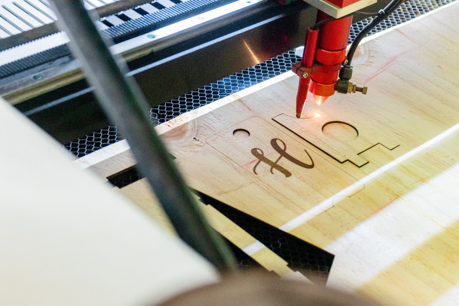 Laser engraving equipment cutting a design into wood in the workshop